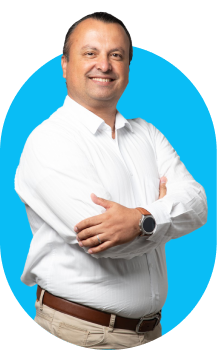 Hombre profesional con camisa blanca y brazos cruzados sonriendo, integrante del equipo de soluciones tecnológicas Infosgroup